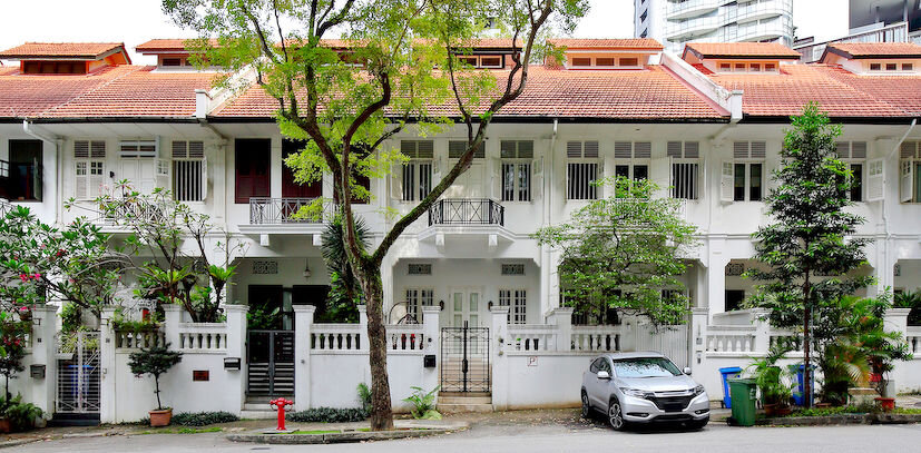 Heritage townhouses with skyscrapers as neighbours